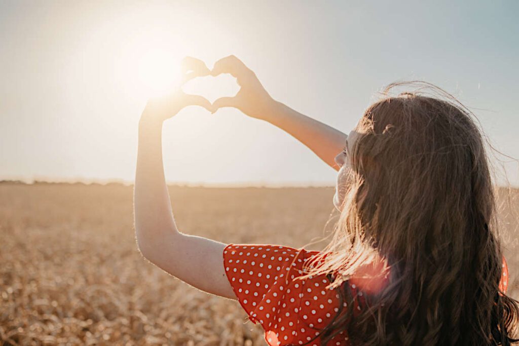 Frau steht in der Sonne und tankt Vitamin D3 tagesdosis