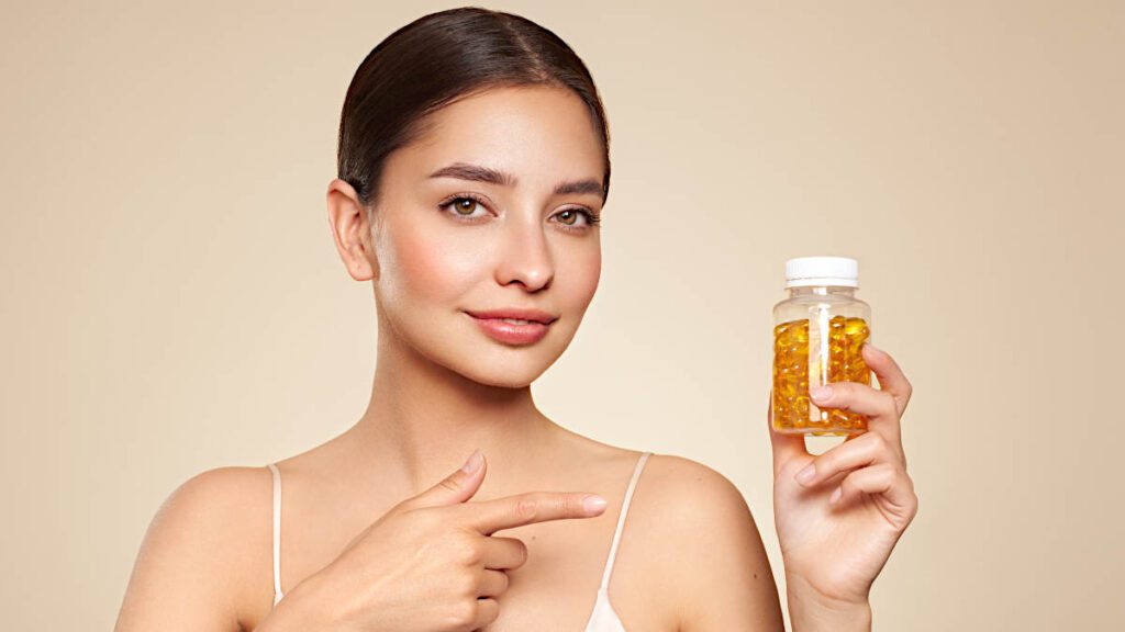 schöne frau hält eine flasche algenöl omega 3 in kapselform in der hand