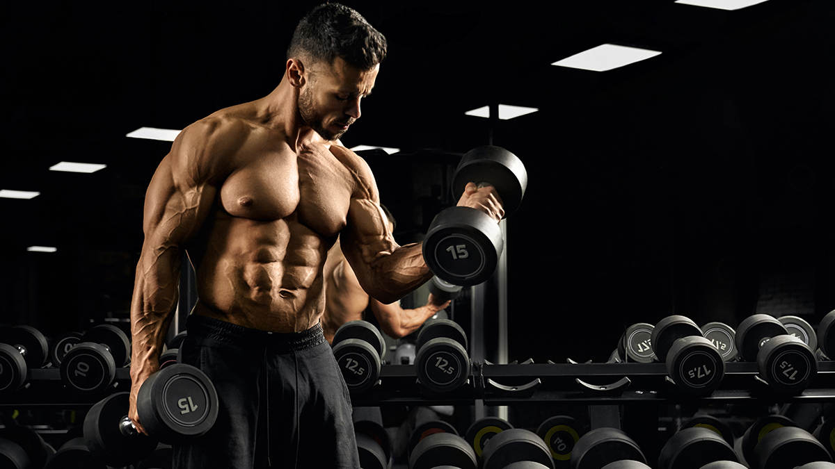 kräftiger Mann beim krafttraining trainiert großen bizeps muskel mit der hantel im gym