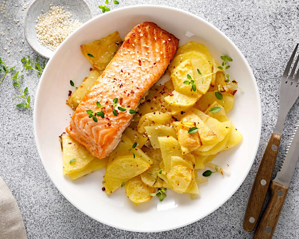 High Protein Rezept zum Abnehmen GEBACKENE KARTOFFELN MIT QUARK UND LACHS auf einem Teller serviert.