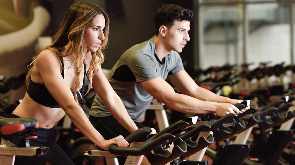 mann und frau beim cardio training auf dem fahrrad