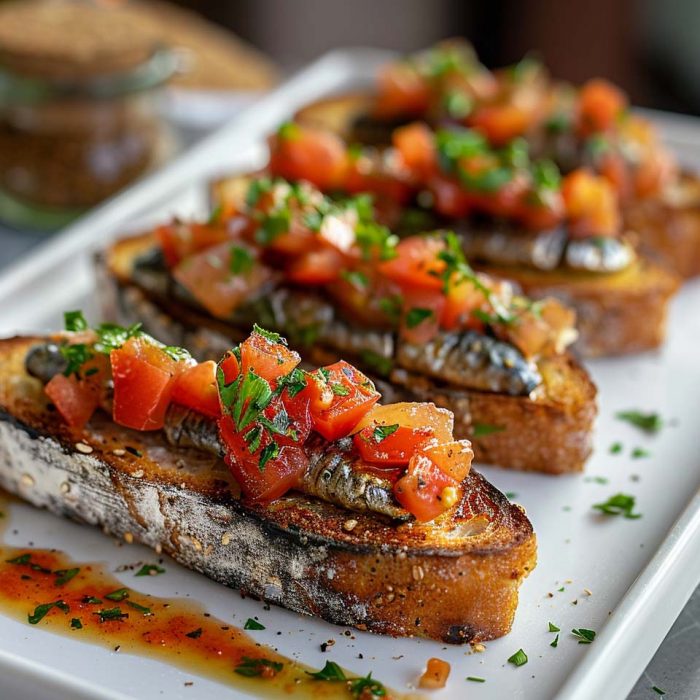 High Protein Rezept zum Abnehmen GEBRATENE SARDINEN AUF VOLLKORNTOAST MIT TOMATENSAUCE auf einem Teller serviert.